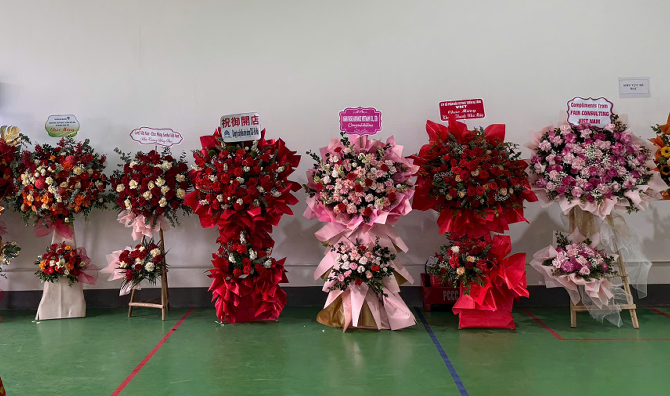 赤やピンクを基調とした祝い花が並んでいる。